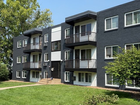 A modern apartment building with balconies and doors.