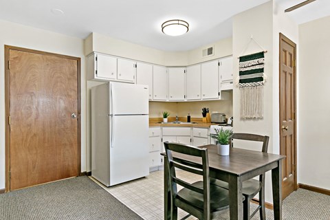 a kitchen with a table and chairs and a refrigerator