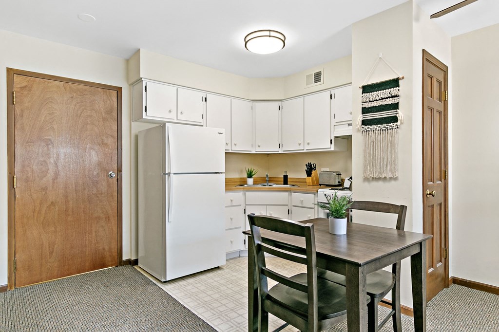 a kitchen with a table and chairs and a refrigerator