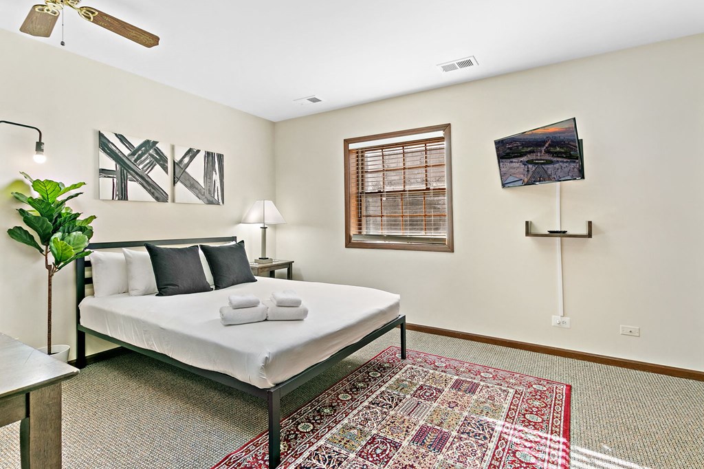 a bedroom with a bed and a rug and a window