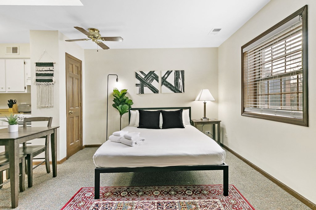 a bedroom with a bed and a ceiling fan