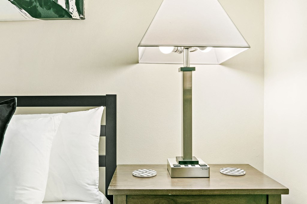 a bedroom with a bed and a table with a lamp