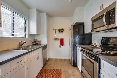 a kitchen with stainless steel appliances and white cabinets