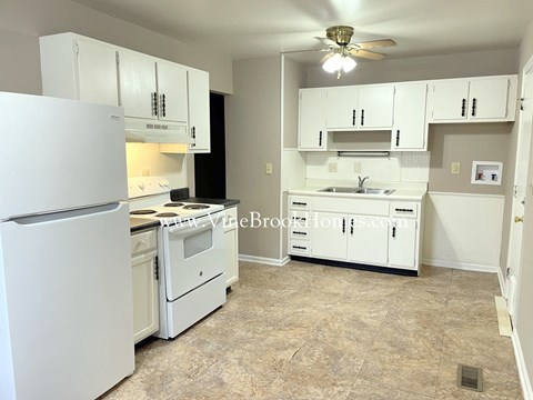 a white kitchen with white appliances and white cabinets