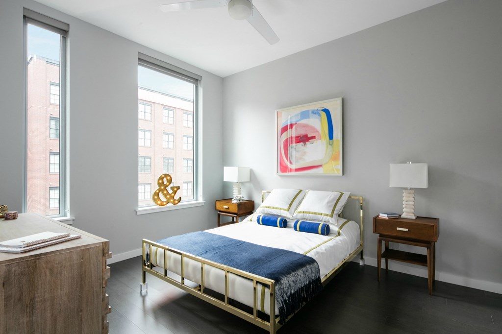 a bedroom with a bed and two windows