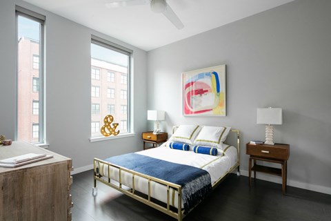 a bedroom with a bed and two windows