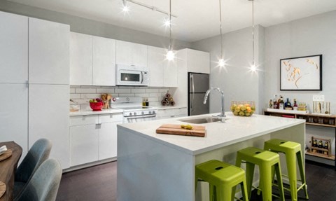 a white kitchen with green stools and a counter top