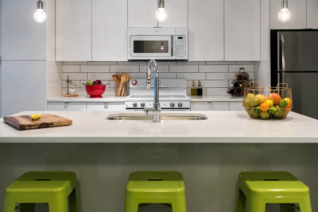 a kitchen with green stools in front of a counter