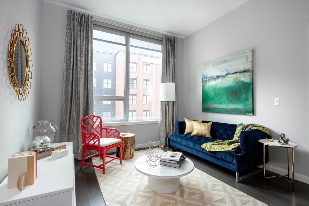 a living room with a blue couch and a large window