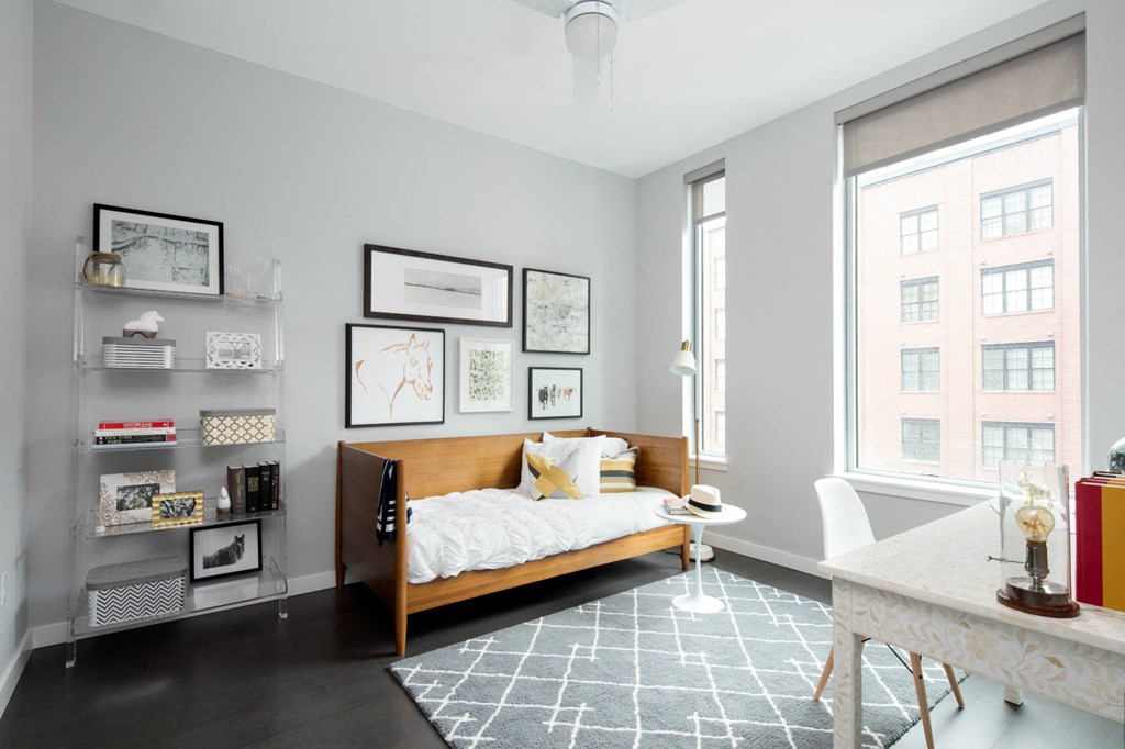 a bedroom with a bed and a large window