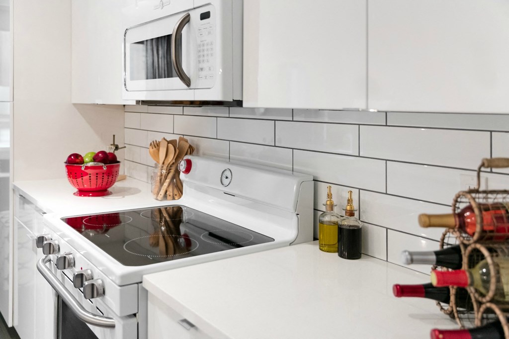 a white kitchen with a stove and a microwave