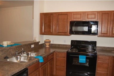 A black oven with a blue towel on it.
