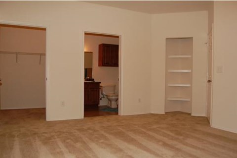 A room with a toilet and a cabinet in it.