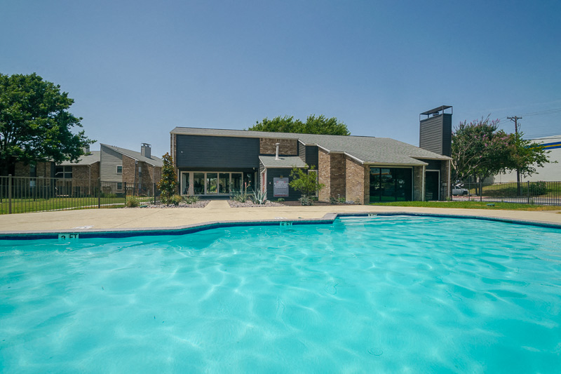 a swimming pool with a house in the background