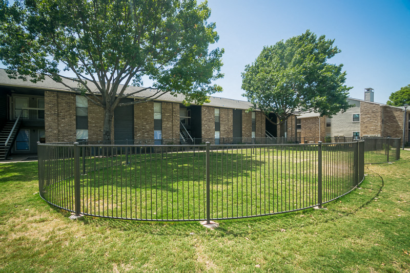 an image of a fence in front of an apartment building