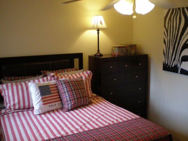 a bedroom with a bed with pillows and a dresser