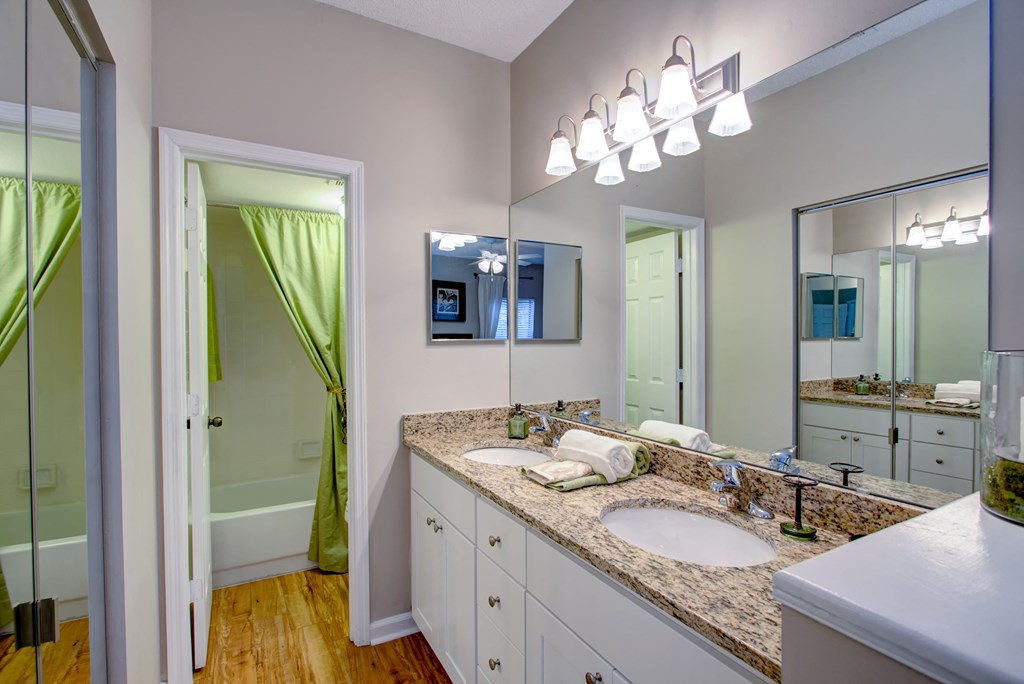 a bathroom with two sinks and a mirror and a shower