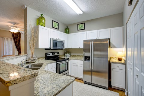 a kitchen with stainless steel appliances and granite counter tops