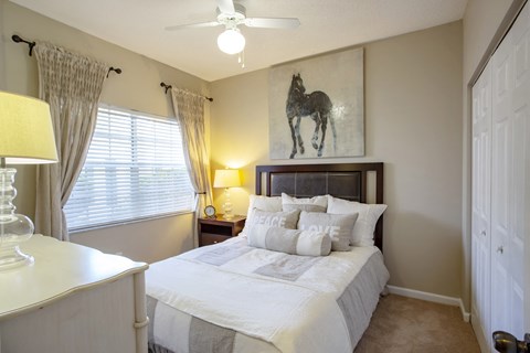 a bedroom with a large bed and a painting of a horse
