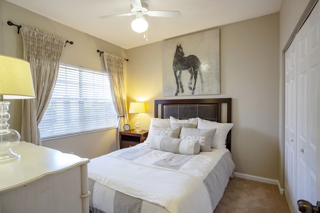 a bedroom with a large bed and a painting of a horse