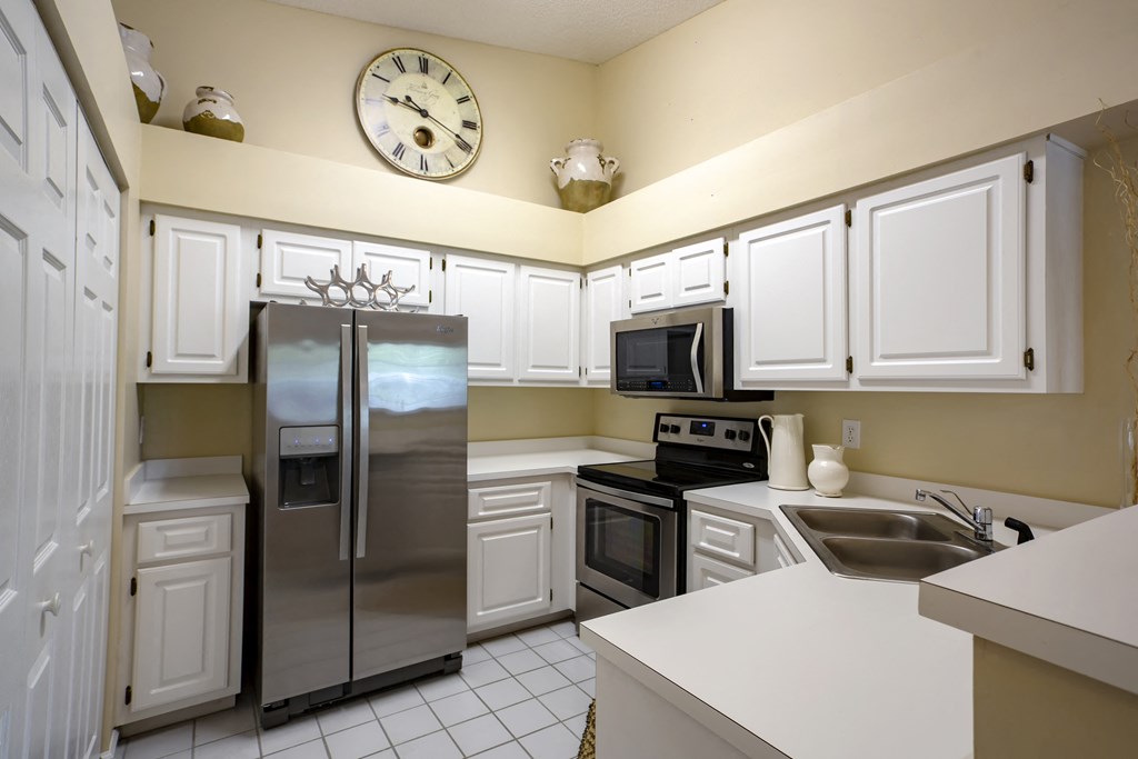 a kitchen with stainless steel appliances and a clock