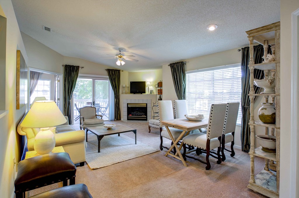 a living room with a table and chairs and a fireplace
