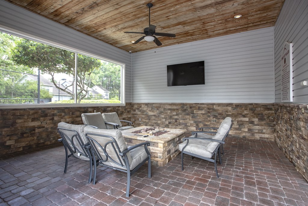 a covered patio with a table and chairs and a tv
