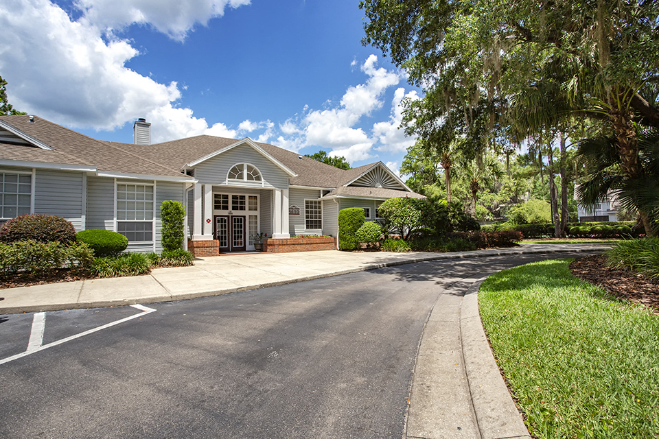 a house with a driveway and trees in front of it