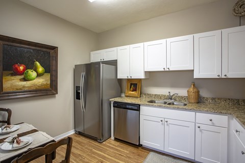 a kitchen with stainless steel appliances and white cabinets