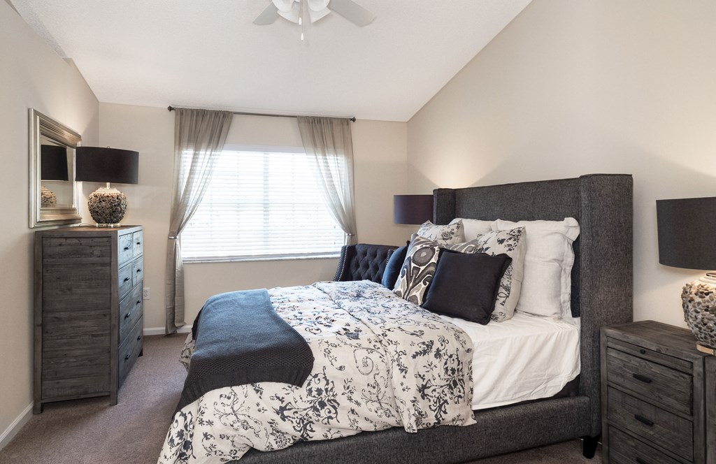 a bedroom with a bed and a dresser and a window