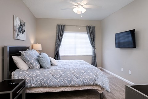 a bedroom with a large bed and a ceiling fan