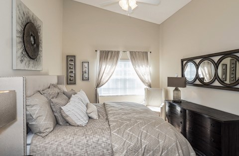 a bedroom with a bed and a dresser and a window