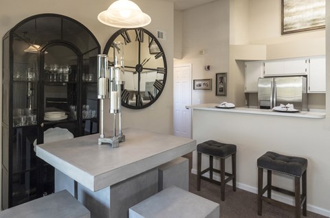 a kitchen with a large clock on the wall and a counter with stools