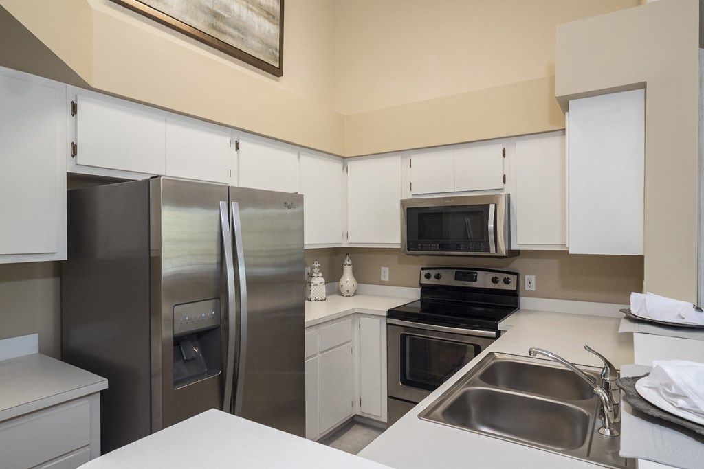 a kitchen with stainless steel appliances and white cabinets
