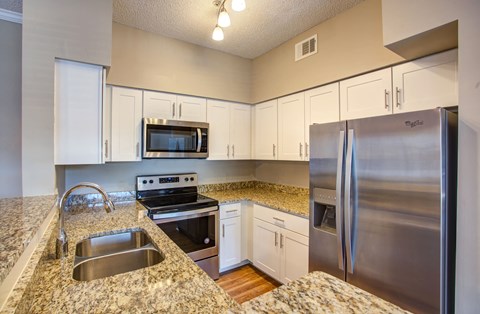 a kitchen with granite counter tops and stainless steel appliances