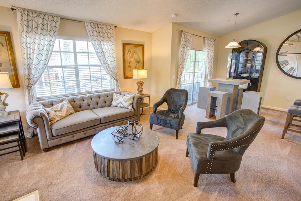 a living room with a couch and chairs and a table