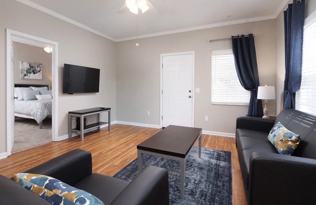 a living room with black leather furniture and a tv