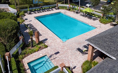 a view of the pool and poolside seating area of a resort style swimming pool