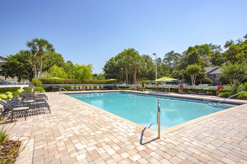 a swimming pool with chairs and a resort style pool