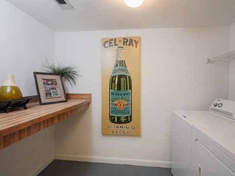 a laundry room with a poster of a bottle of beer on the wall