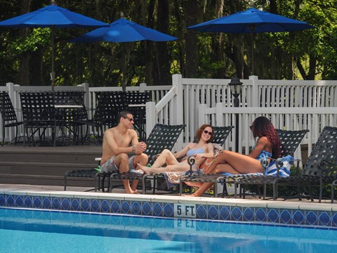 a group of people sitting by a swimming pool