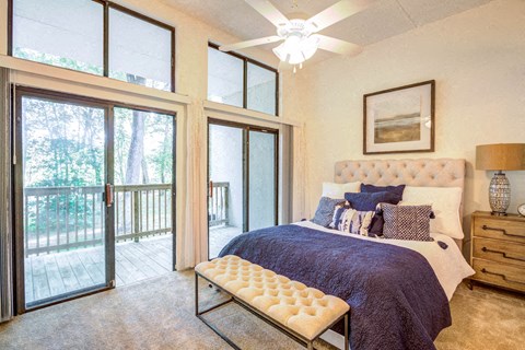 a bedroom with a bed and sliding glass doors to a balcony