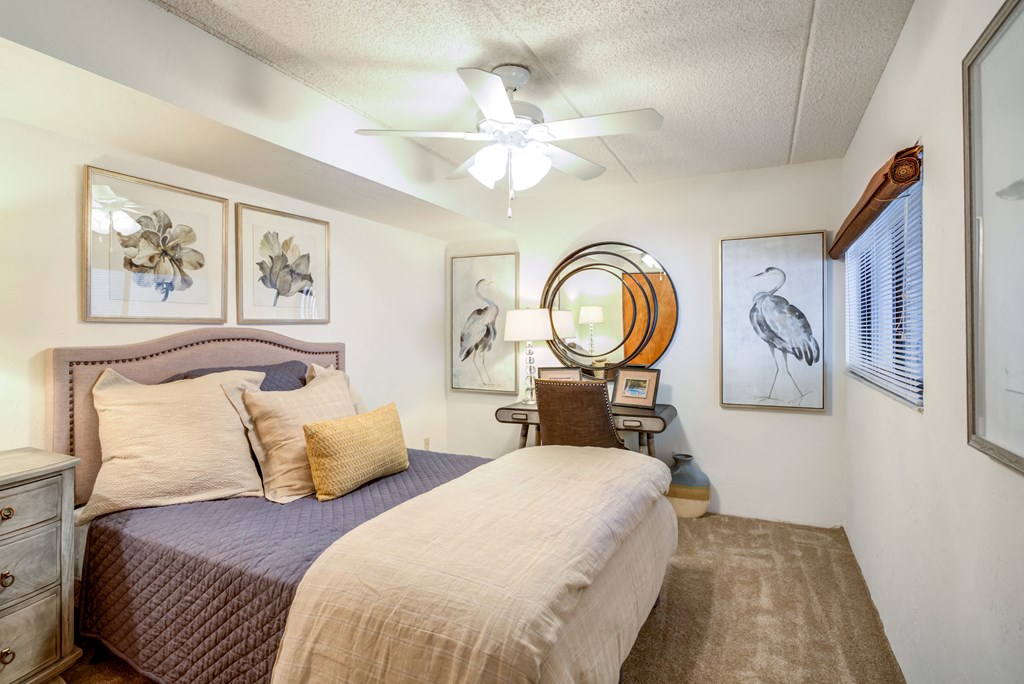 a bedroom with a bed and a ceiling fan