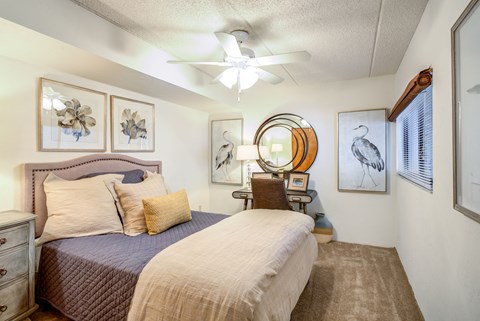 a bedroom with a bed and a ceiling fan