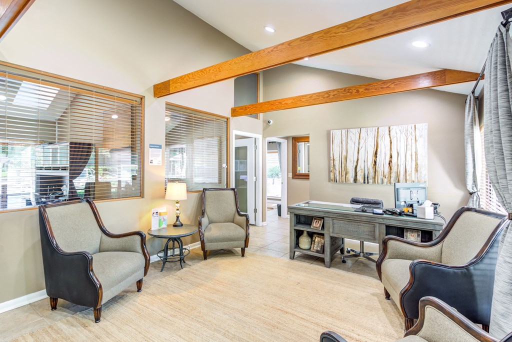 a home office with a desk and chairs and a large window