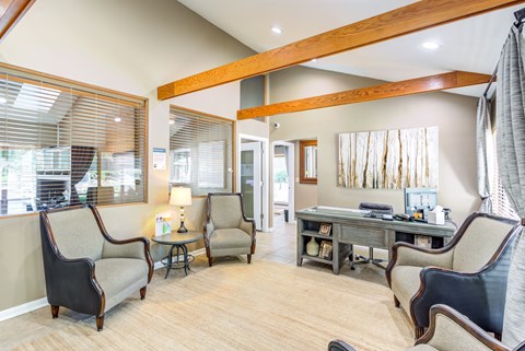 a home office with a desk and chairs and a large window