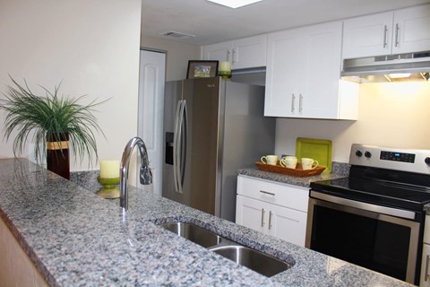 a kitchen with granite counter tops and stainless steel appliances