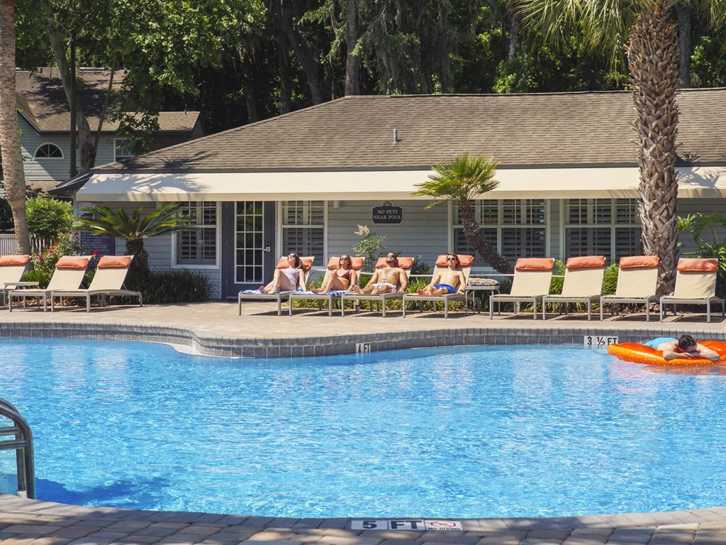 a group of people sitting around a swimming pool