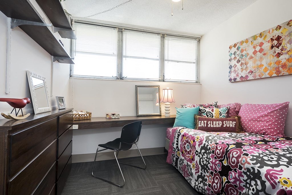 a bedroom with a bed and a desk