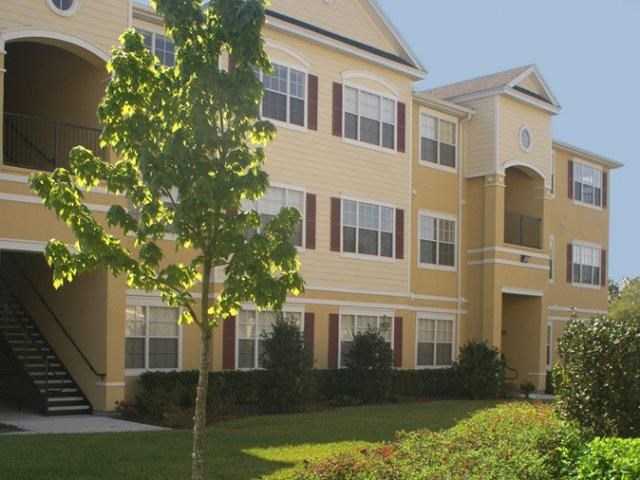 a large yellow building with a tree in front of it